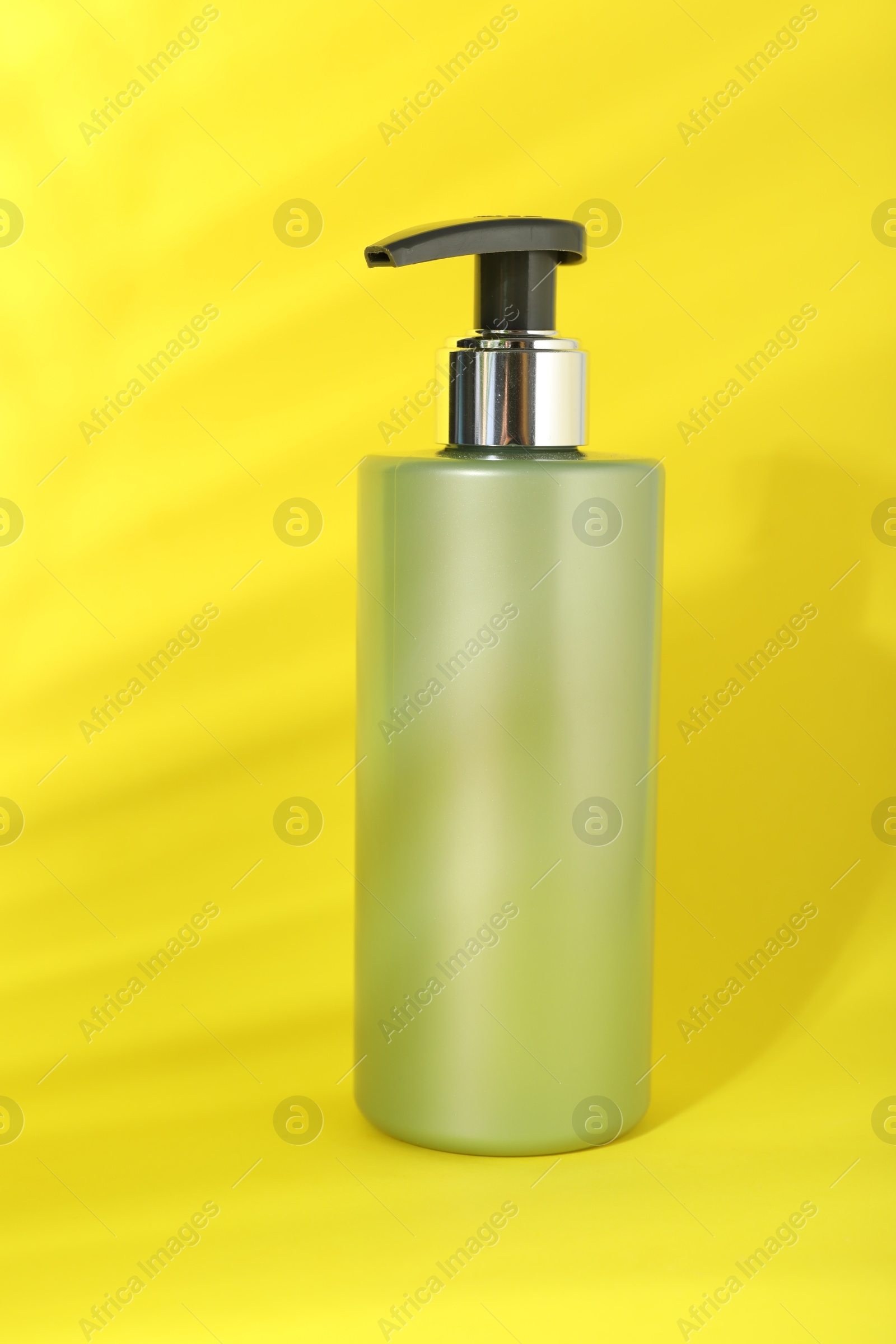 Photo of One shampoo in bottle on yellow background