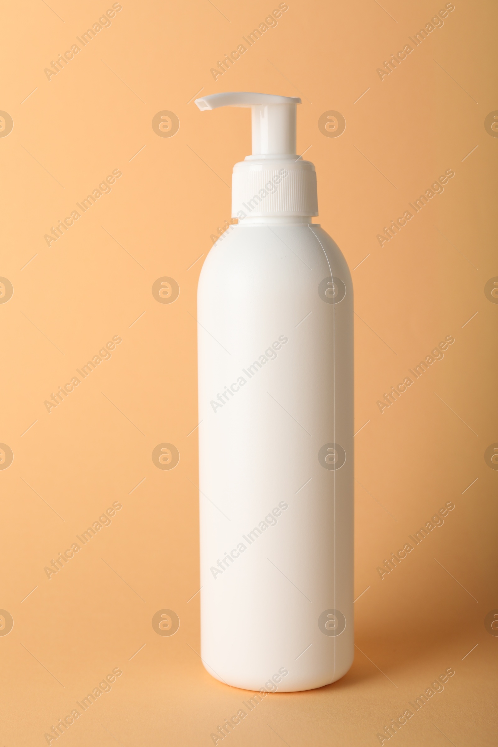 Photo of One shampoo in bottle on pale orange background