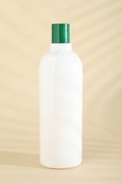 One shampoo in bottle on beige background