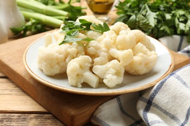 Photo of Tasty cauliflower with parsley on wooden table, closeup