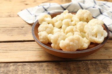 Photo of Tasty cauliflower in bowl on wooden table, closeup