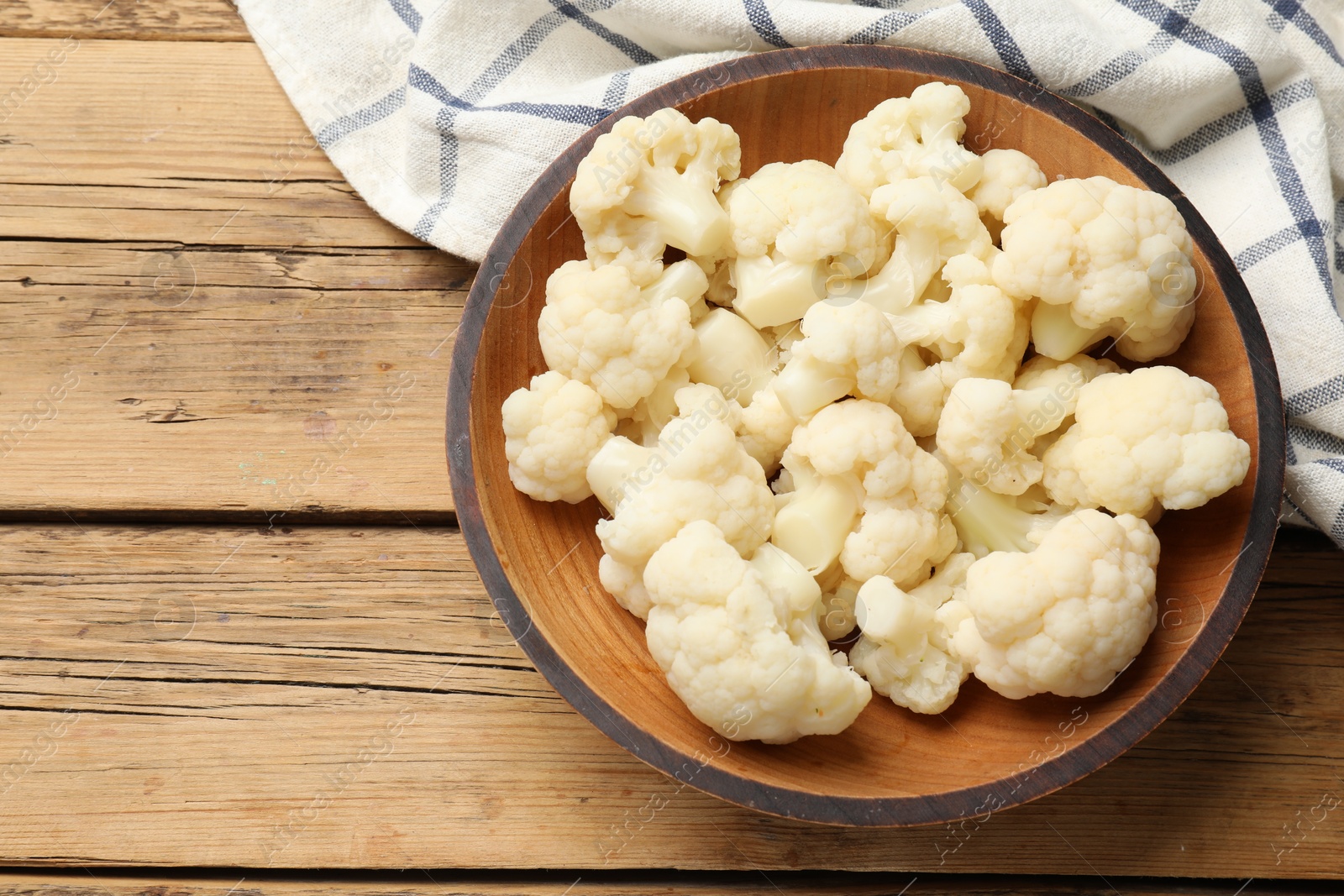 Photo of Tasty cauliflower on wooden table, top view. Space for text