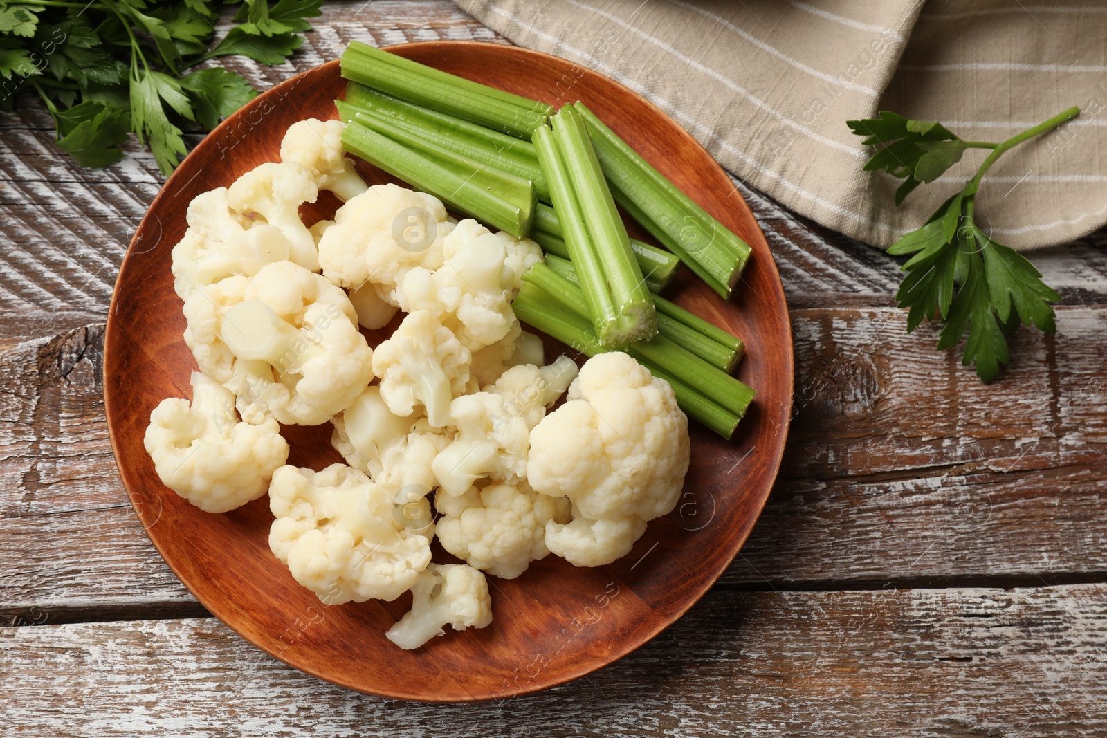 Photo of Tasty cauliflower with celery on wooden table, flat lay