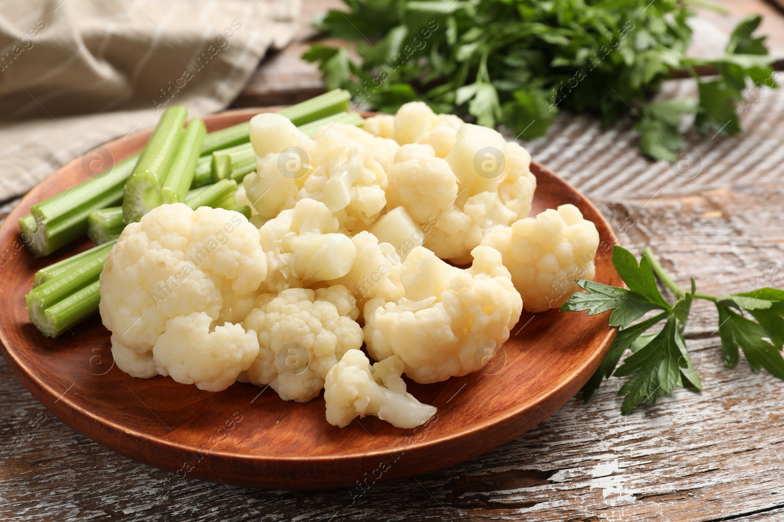 Photo of Tasty cauliflower with celery on wooden table, closeup