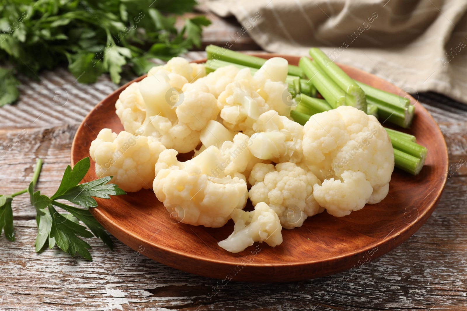 Photo of Tasty cauliflower with celery on wooden table, closeup