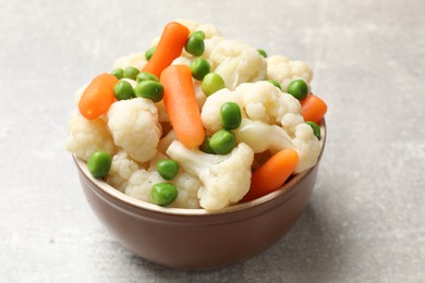 Photo of Tasty cauliflower with baby carrots and green peas on grey table, closeup