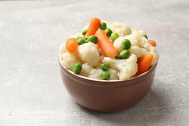 Photo of Tasty cauliflower with baby carrots and green peas on grey table, closeup