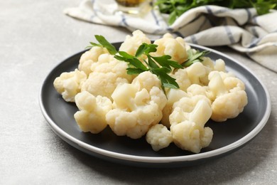 Photo of Tasty cauliflower with parsley on grey table, closeup