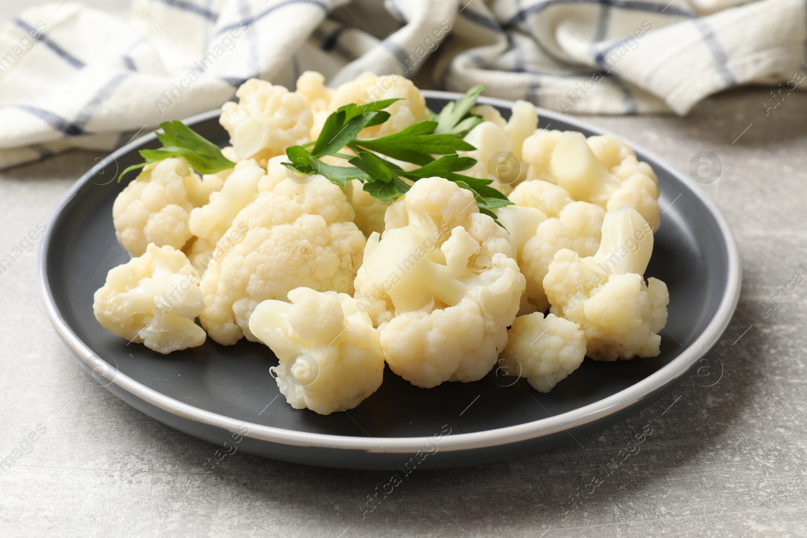 Photo of Tasty cauliflower with parsley on grey table, closeup