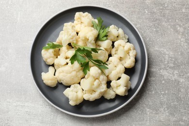 Photo of Tasty cauliflower with parsley on grey table, top view