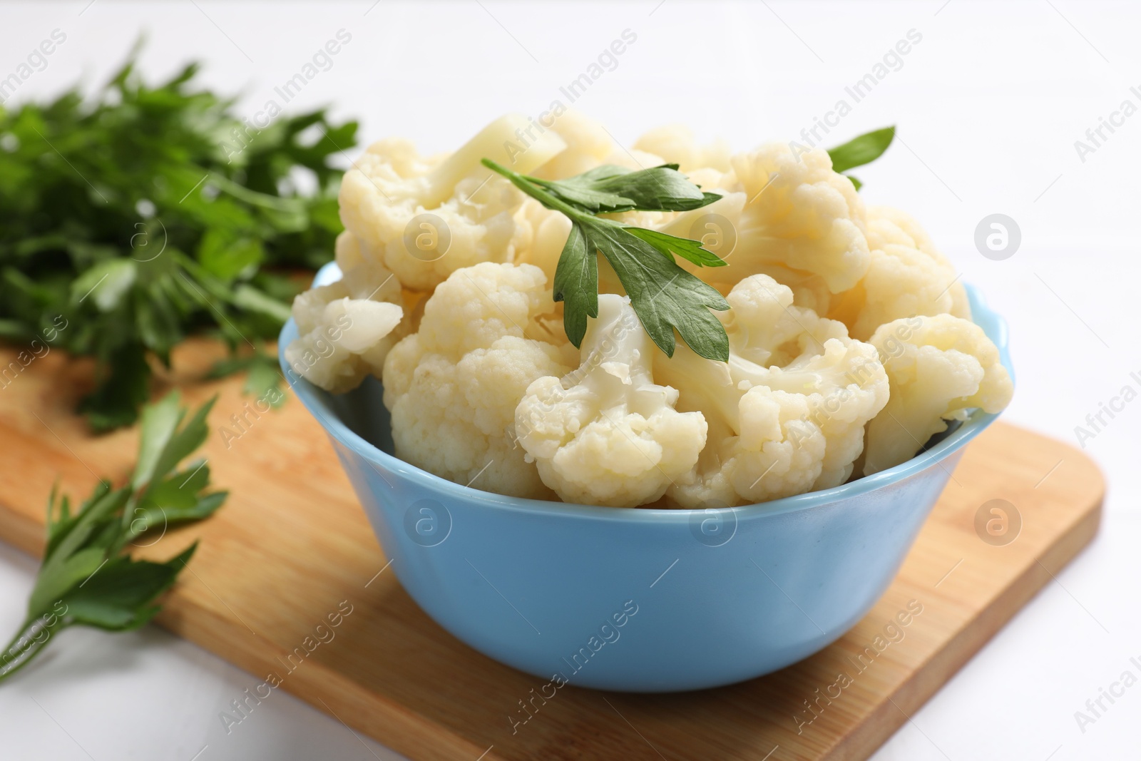 Photo of Tasty cauliflower with parsley on white table, closeup