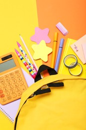 Photo of Backpack and different school stationery on color background, flat lay