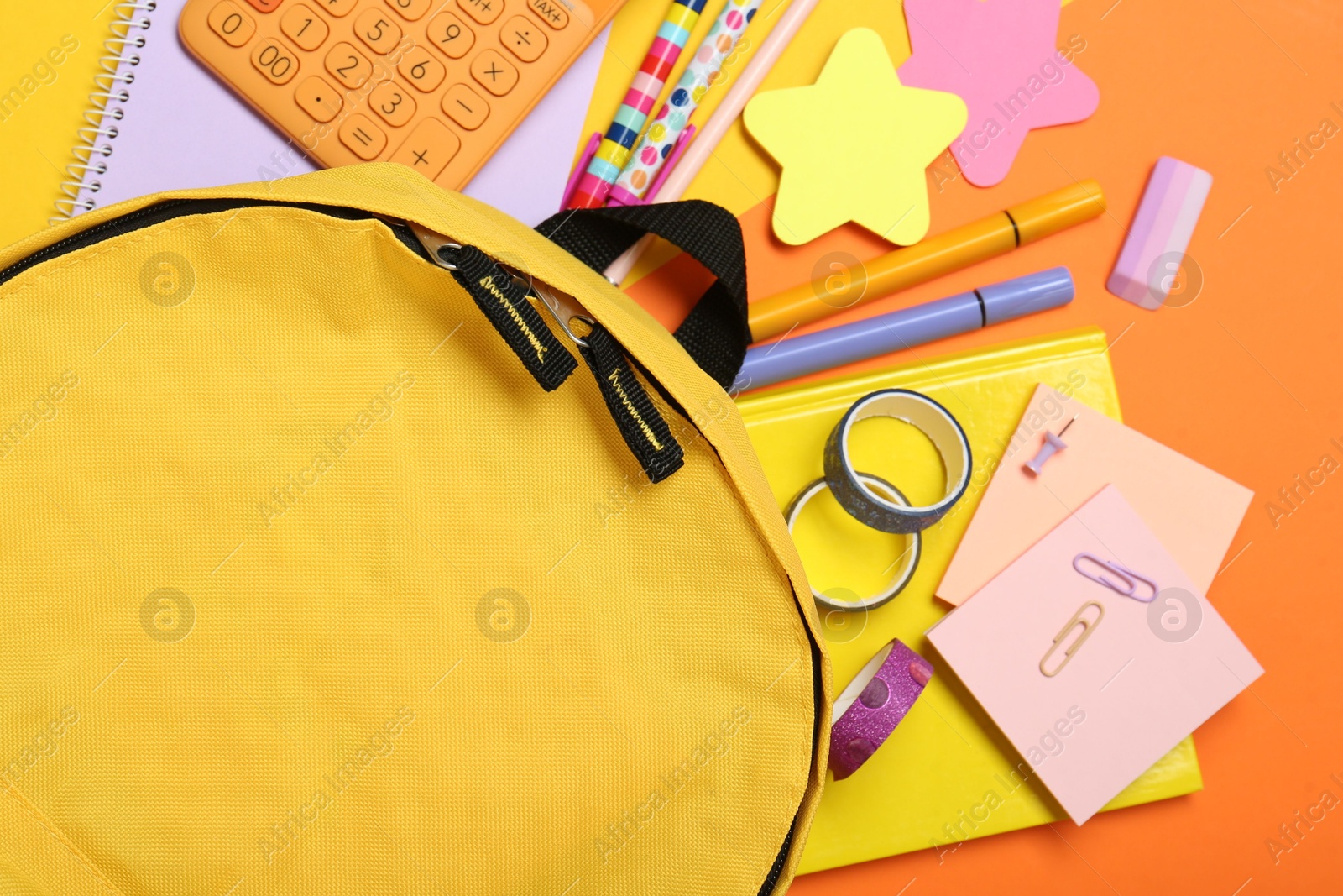 Photo of Backpack and different school stationery on color background, flat lay