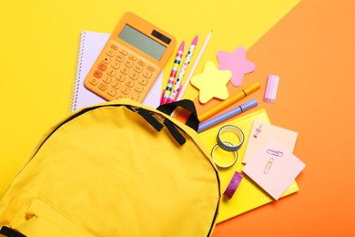 Photo of Backpack and different school stationery on color background, flat lay