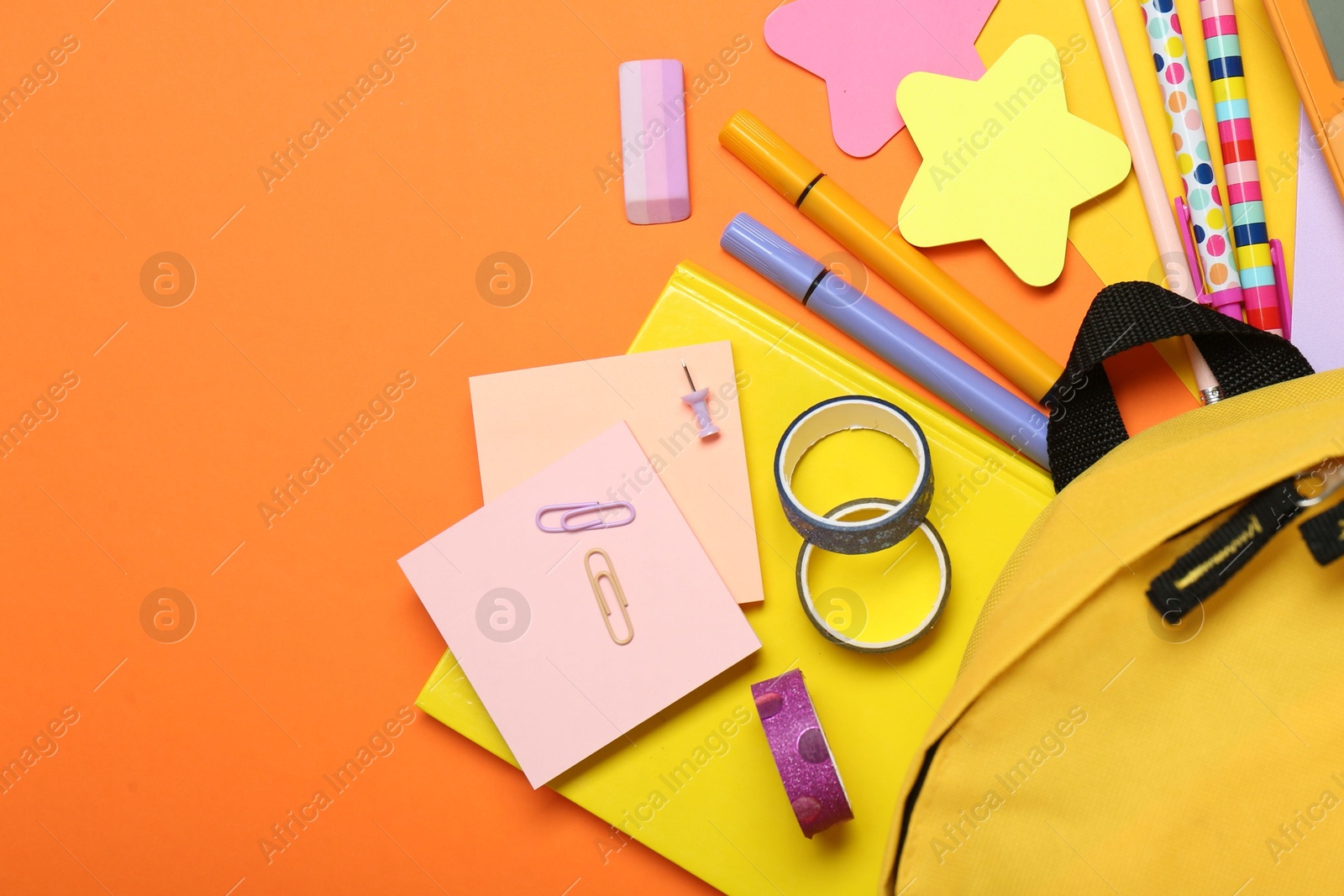 Photo of Backpack and different school stationery on color background, flat lay. Space for text