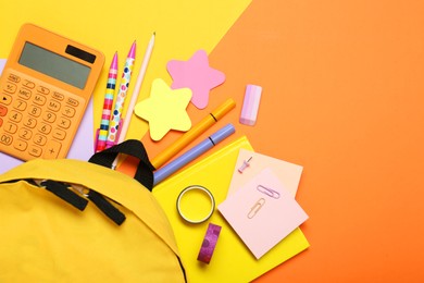 Photo of Backpack and different school stationery on color background, flat lay. Space for text