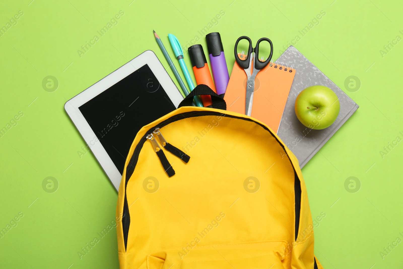 Photo of Backpack, different school stationery and apple on light green background, flat lay