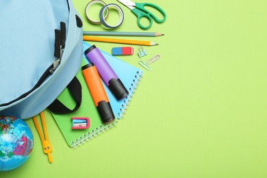 Backpack and different school stationery on light green background, flat lay. Space for text