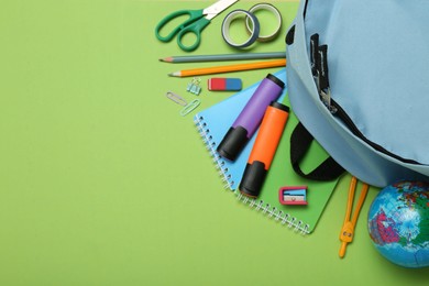 Backpack and different school stationery on light green background, flat lay. Space for text