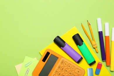 Photo of Different school supplies and calculator on light green background, flat lay. Space for text