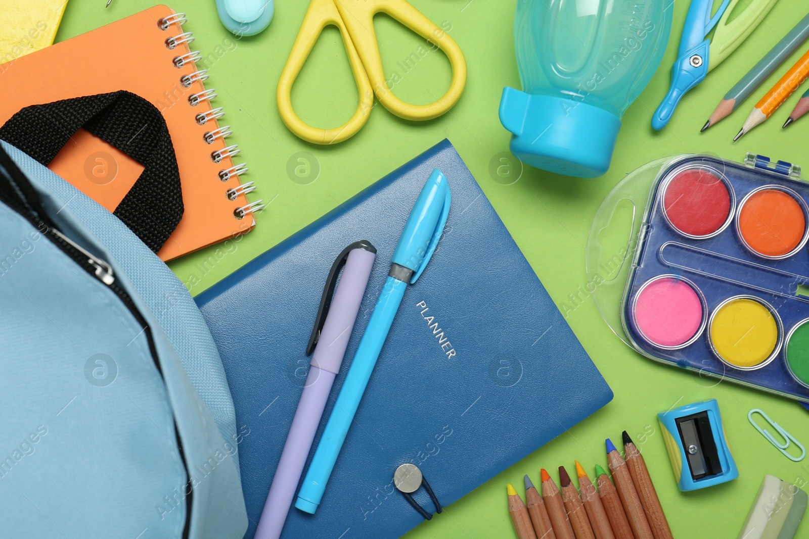 Photo of Backpack and different school stationery on light green background, flat lay