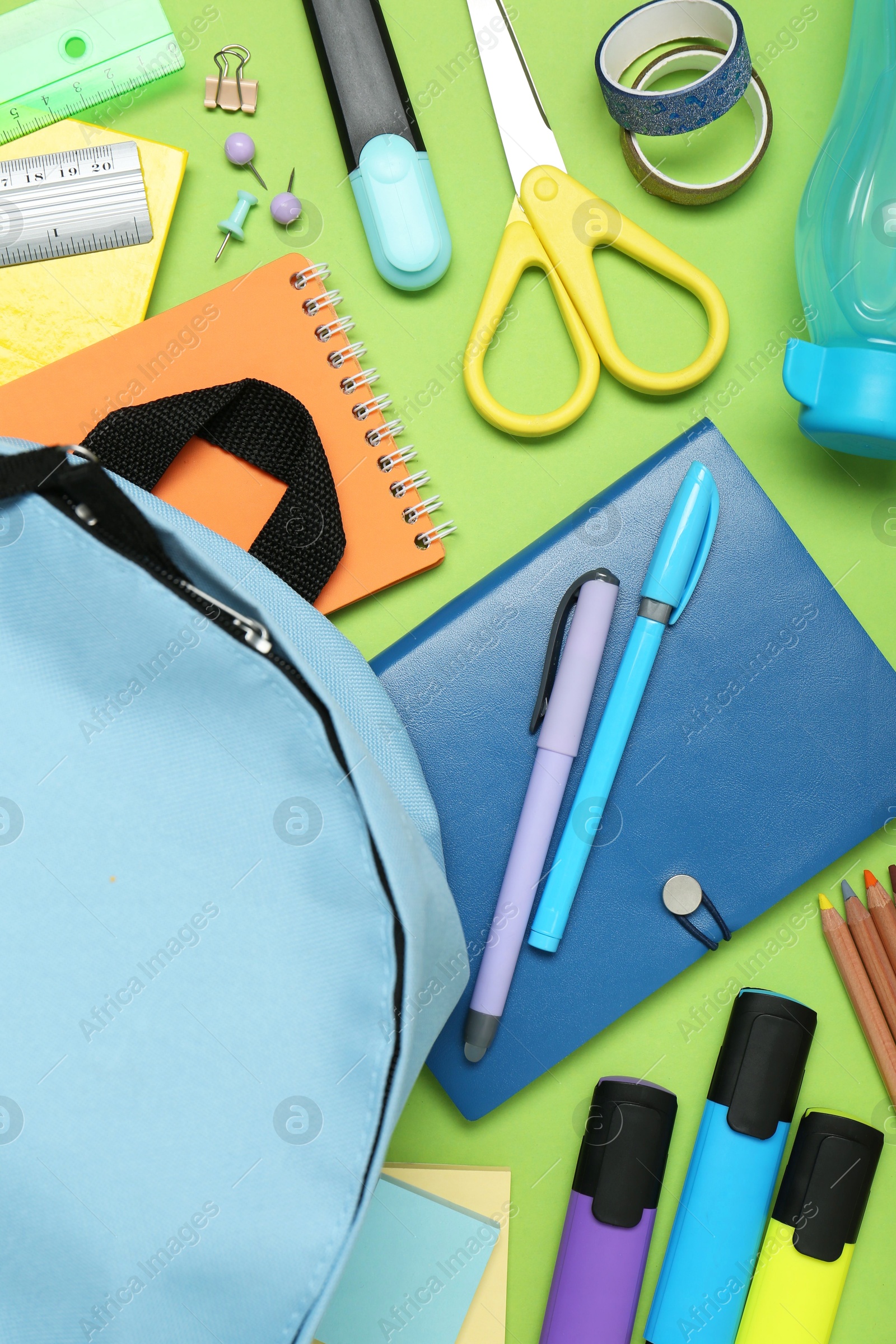 Photo of Backpack and different school stationery on light green background, flat lay