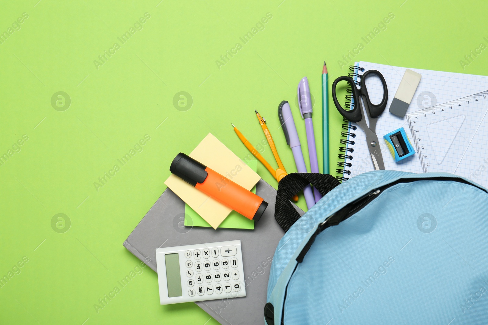 Photo of Backpack and different school stationery on light green background, flat lay. Space for text