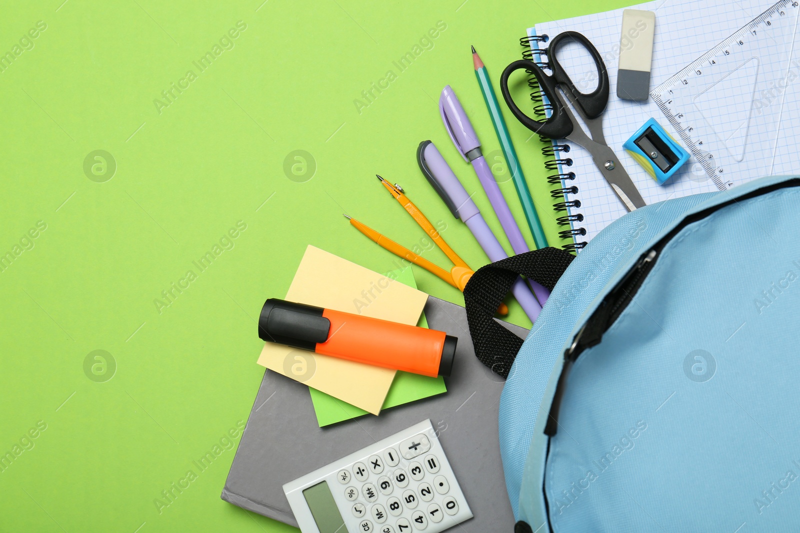 Photo of Backpack and different school stationery on light green background, flat lay. Space for text