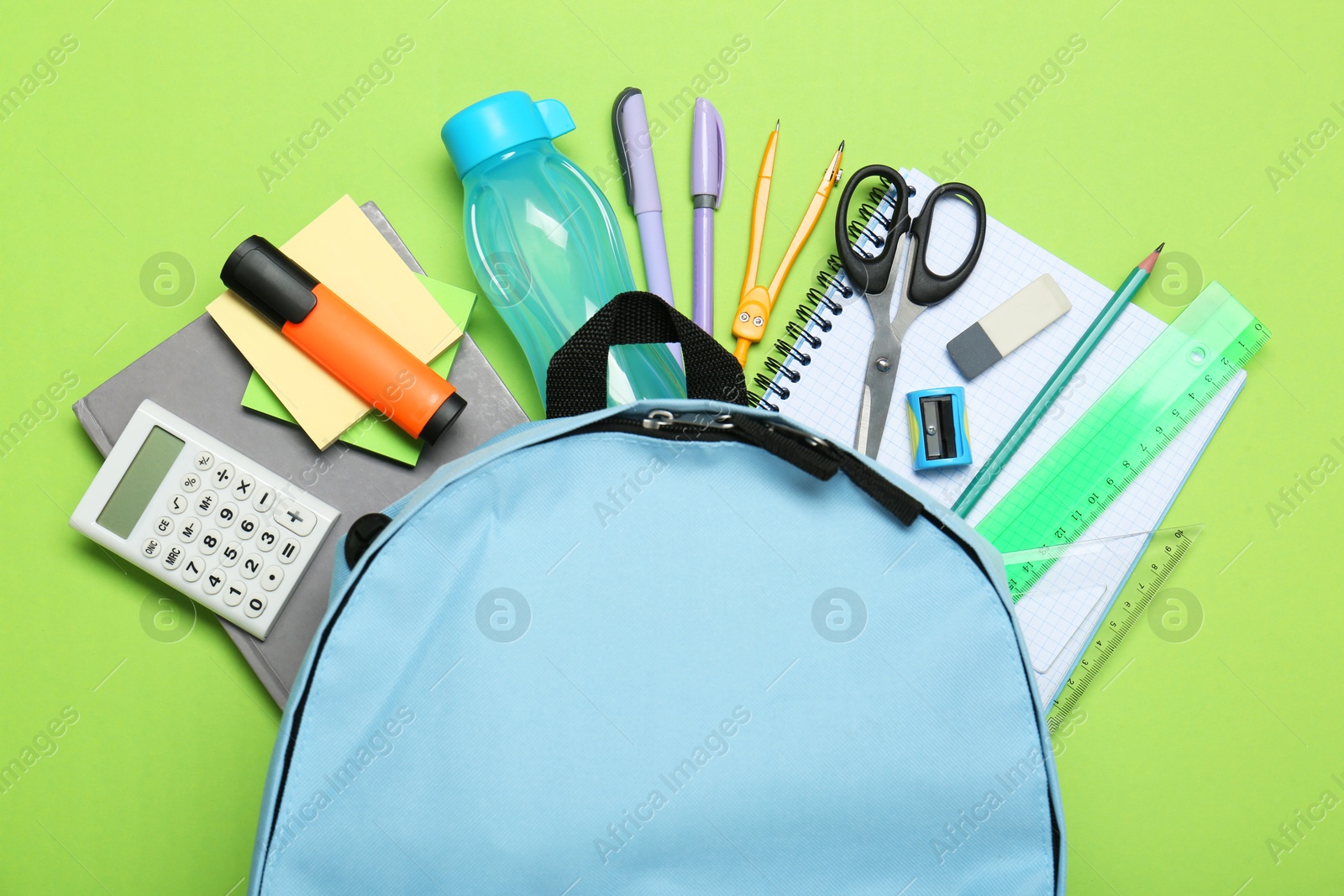 Photo of Backpack and different school stationery on light green background, flat lay