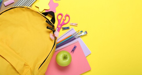 Photo of School backpack and stationery on yellow background, flat lay. Space for text