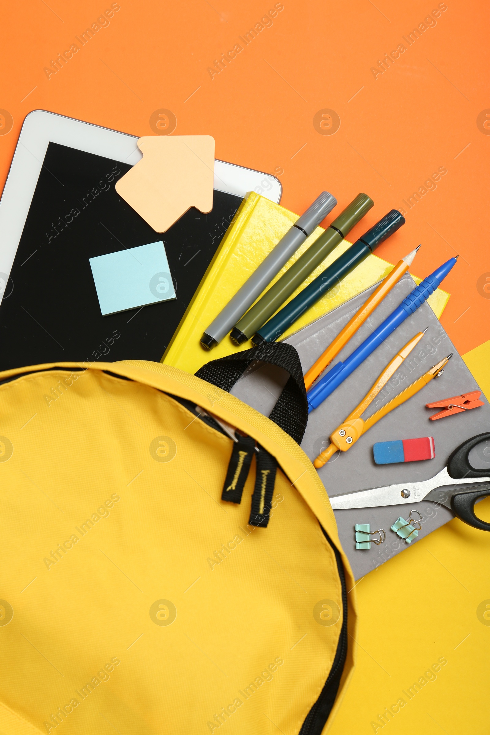 Photo of School backpack, tablet and stationery on color background, flat lay