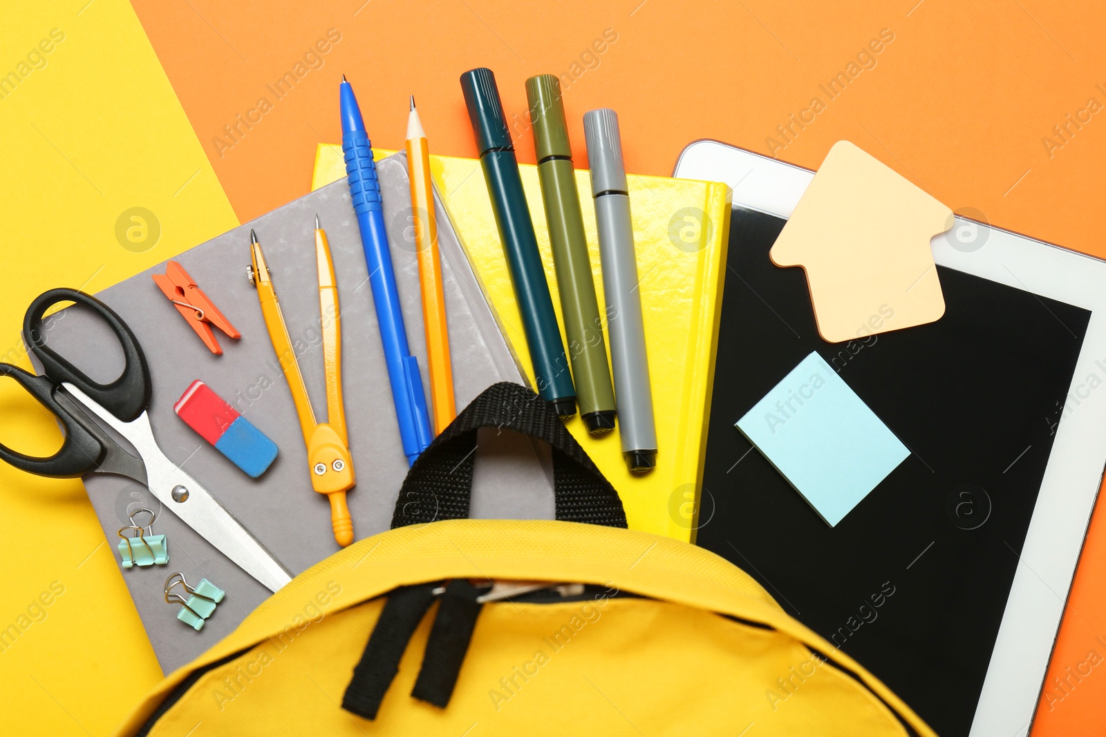 Photo of School backpack, tablet and stationery on color background, flat lay