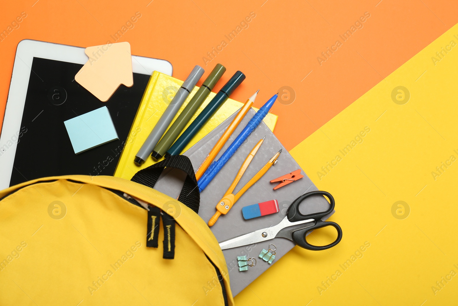 Photo of School backpack, tablet and stationery on color background, flat lay. Space for text