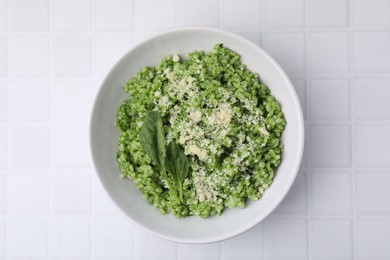 Photo of Delicious spinach risotto with parmesan cheese on white tiled table