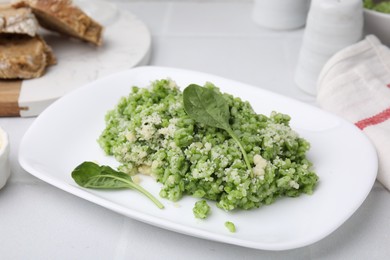 Photo of Delicious spinach risotto with parmesan cheese on white tiled table, closeup