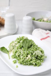 Photo of Delicious spinach risotto with parmesan cheese on white tiled table