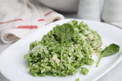 Photo of Delicious spinach risotto with parmesan cheese on white tiled table, closeup