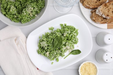 Photo of Delicious spinach risotto with parmesan cheese on white tiled table, flat lay