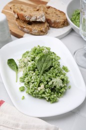 Photo of Delicious spinach risotto with parmesan cheese on white tiled table