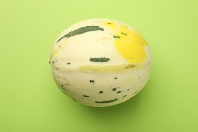 Photo of Fresh ripe honeydew melon on green background, top view