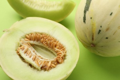 Photo of Fresh ripe honeydew melons on green background, closeup