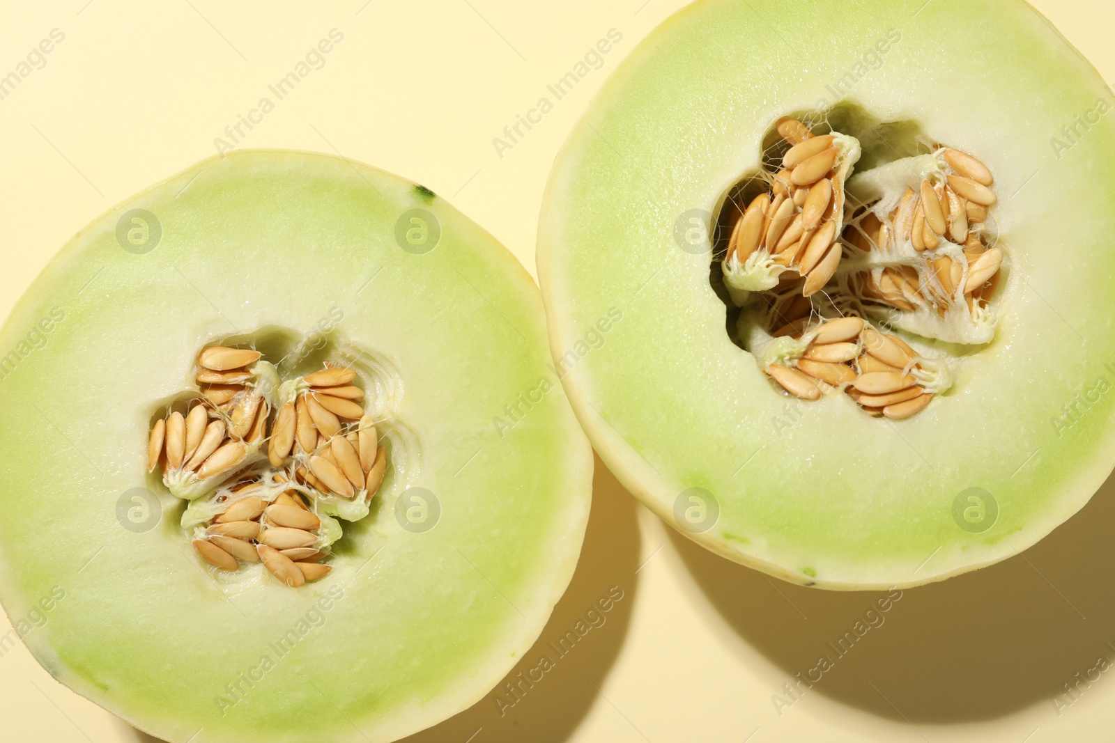 Photo of Cut fresh ripe honeydew melon on beige background, top view