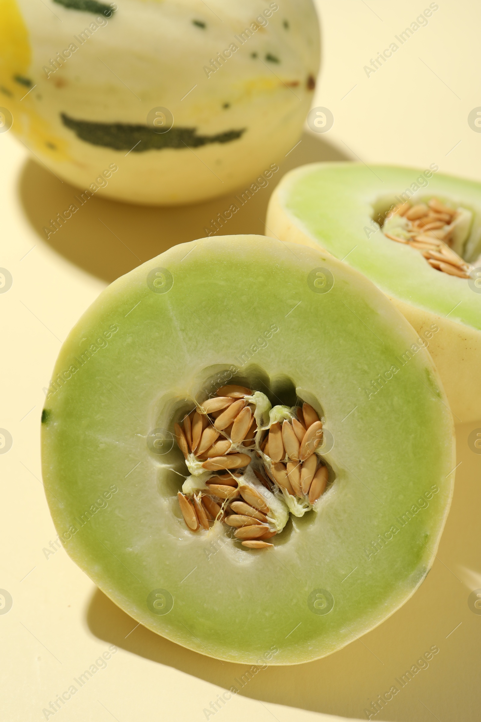 Photo of Fresh ripe honeydew melons on beige background, closeup