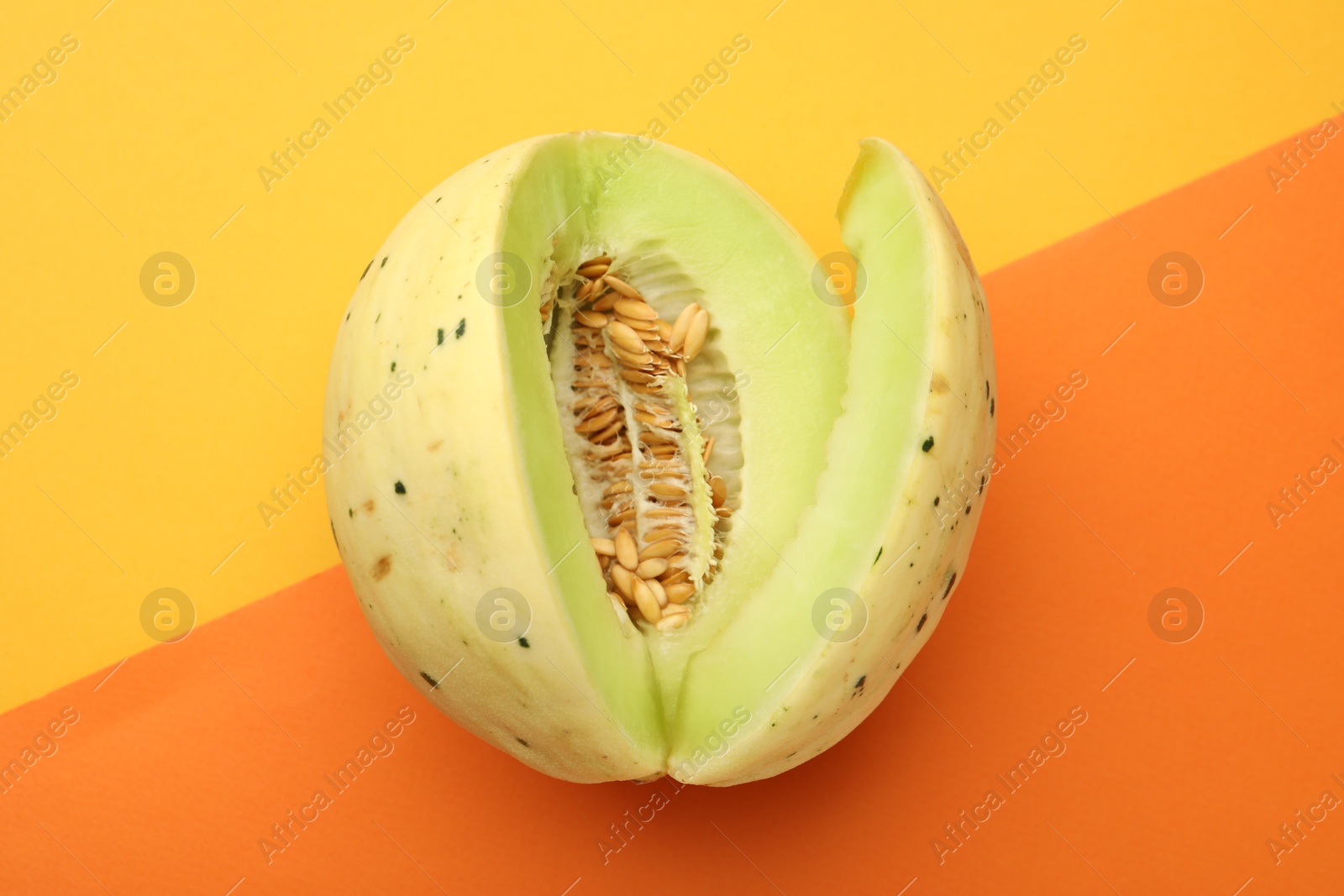 Photo of Cut fresh ripe honeydew melon on color background, top view