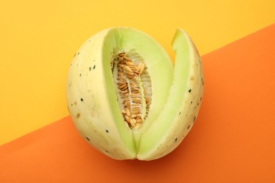 Photo of Cut fresh ripe honeydew melon on color background, top view