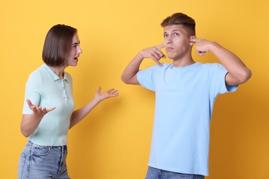 Photo of Emotional young couple arguing on orange background