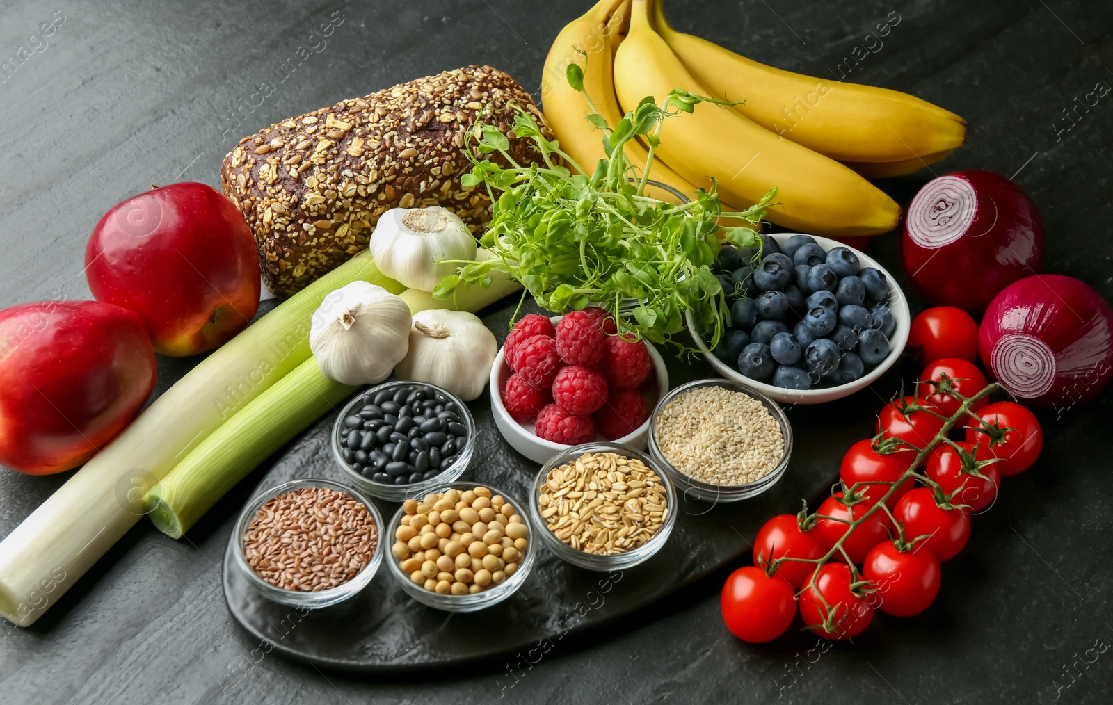 Photo of Different fresh products on black table. Source of prebiotics