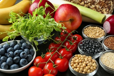 Photo of Different fresh products on black table. Source of prebiotics