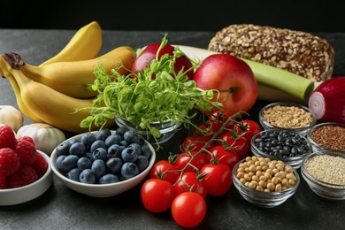 Photo of Different fresh products on black table. Source of prebiotics