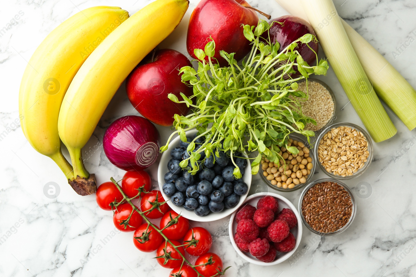 Photo of Different fresh products on white marble table, flat lay. Source of prebiotics